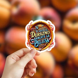 May include: A white sticker with a gold frame and a peach design. The sticker says "Si te gusta el durazno bancate la pelusa".