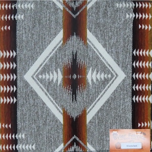 May include: A gray and white fabric with a geometric pattern in shades of brown, orange, and red. The fabric has a Southwestern design and is called "Arizona Dusk".