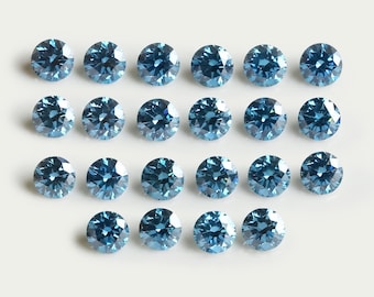 Könnte beinhalten: Eine Ansammlung von neunzehn runden, facettierten blauen Edelsteinen, die in einem Raster angeordnet sind. Jeder Stein weist einen Brillantschliff mit mehreren reflektierenden Oberflächen auf, die ein funkelndes Aussehen erzeugen.