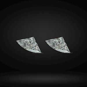 Puede incluir: Dos diamantes incoloros sueltos de talla trillion con facetas triangulares n&iacute;tidas que reflejan la luz. Cada piedra presenta una estructura cristalina clara con un v&eacute;rtice puntiagudo y una base ancha, sobre un fondo oscuro y s&oacute;lido.