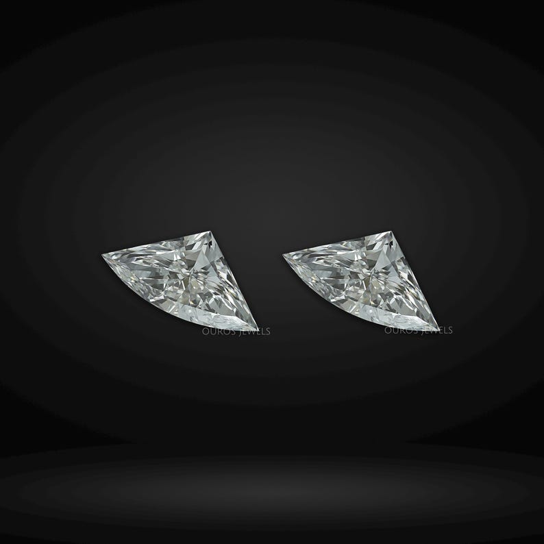 Puede incluir: Dos diamantes incoloros sueltos de talla trillion con facetas triangulares n&iacute;tidas que reflejan la luz. Cada piedra presenta una estructura cristalina clara con un v&eacute;rtice puntiagudo y una base ancha, sobre un fondo oscuro y s&oacute;lido.