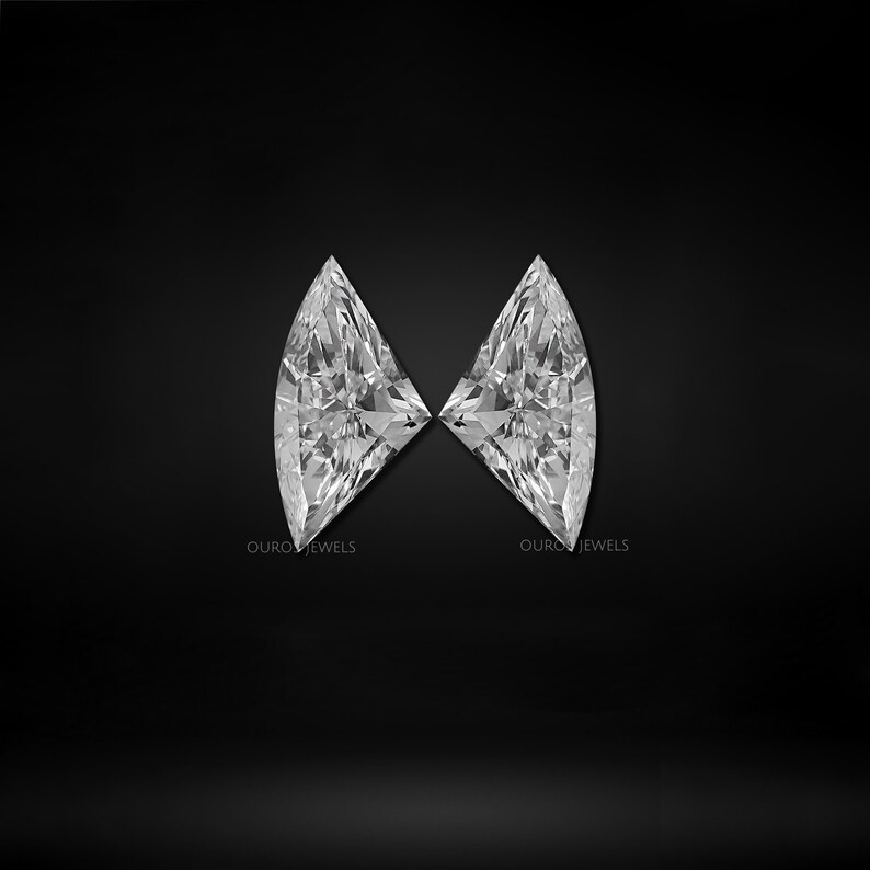 Puede incluir: Dos diamantes sueltos de talla marquesa con una superficie de facetas brillantes, dispuestos sim&eacute;tricamente sobre un fondo negro s&oacute;lido. Cada piedra presenta el texto OUROS JEWELS impreso en letras blancas peque&ntilde;as cerca del borde inferior.