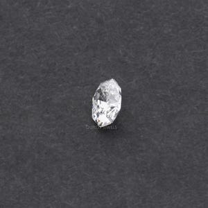 May include: A clear, faceted diamond with a marquise cut, set against a dark gray background. The diamond's multiple facets reflect light, creating a sparkling effect. The word "OURO JEWELS" is visible at the bottom.