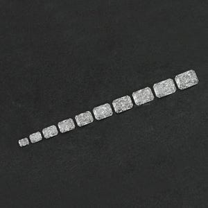 Puede incluir: Una fila de diez piedras preciosas rectangulares, facetadas y transparentes, de diferentes tama&ntilde;os, dispuestas de la m&aacute;s peque&ntilde;a a la m&aacute;s grande sobre una superficie negra.