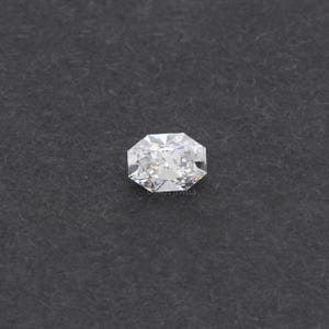 May include: A radiant-cut diamond with a brilliant, multifaceted surface. The gemstone is set against a dark gray background. The diamond's facets reflect light, creating a sparkling effect. The image is a close-up, highlighting the clarity and brilliance of the gem.