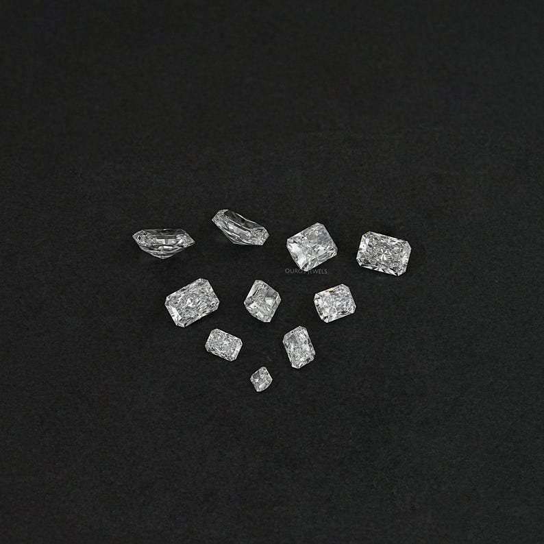 Puede incluir: Surtido de piedras preciosas rectangulares facetadas transparentes sobre un fondo negro.