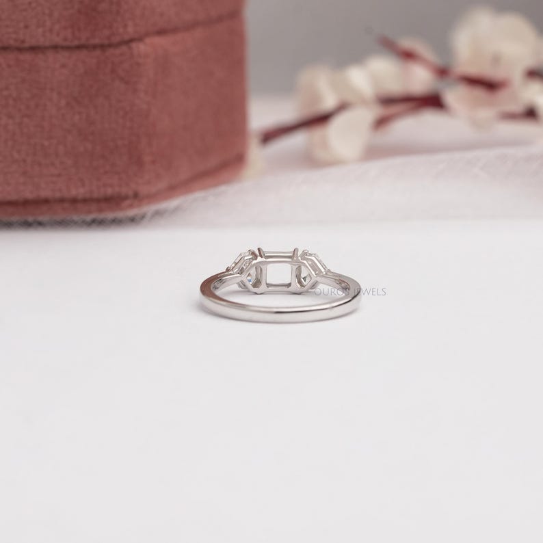 May include: A silver-toned metal ring setting featuring a central rectangular prong mount flanked by two smaller side stone settings. The band is smooth and polished, designed to hold a main gemstone and two accent stones in a three-stone arrangement.