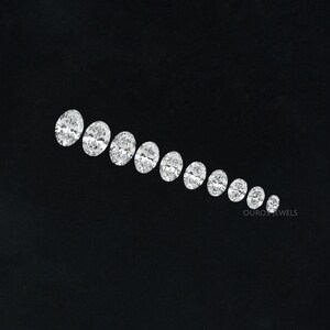 May include: A row of oval-shaped diamonds of varying sizes, arranged in a graduated pattern on a black background.