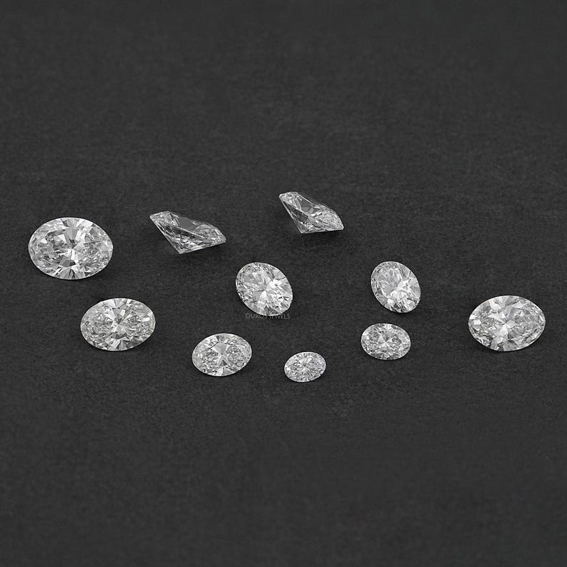 Pu&ograve; includere: Una collezione di diamanti rotondi e ovali di varie dimensioni su uno sfondo nero.