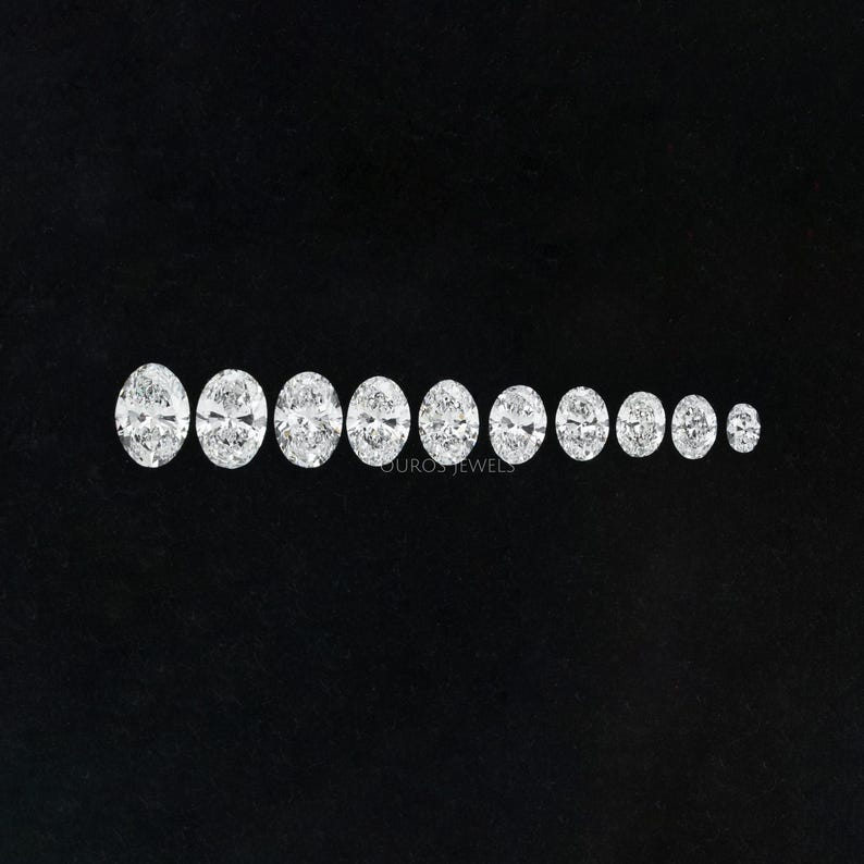 May include: A set of 10 oval-shaped, clear gemstones of varying sizes, arranged in a row from largest to smallest on a black background.