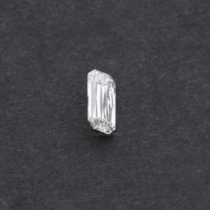 May include: A clear, rectangular emerald cut diamond gemstone on a dark gray background.