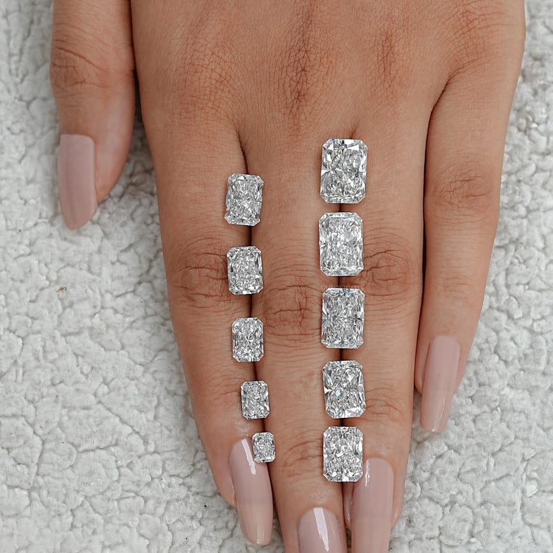 Puede incluir: Un conjunto de ocho diamantes de talla radiante de diferentes tama&ntilde;os, mostrados en una mano.