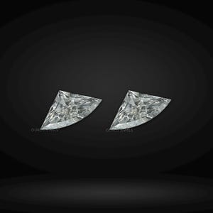 Puede incluir: Dos diamantes sueltos de talla escudo con una superficie facetada brillante y un aspecto claro e incoloro. Cada piedra presenta el texto Ouros Jewels impreso en peque&ntilde;as letras blancas cerca del borde inferior sobre un fondo oscuro.
