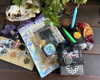 May include: A collection of mystical items, including a skull, crystals, candles, and a tarot deck. The items are arranged on a wooden surface, with a variety of colors and textures. A holographic bag contains earrings and other items.