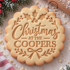 May include: A round, scalloped-edge biscuit stamp featuring the embossed text "Christmas AT THE COOPERS" in the centre. The design includes holly leaves, berries, and a bow motif, with the brand name "Sunny STUDIO VIBES" visible.