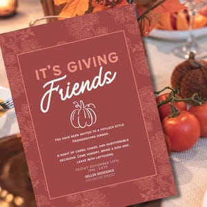 Pode incluir: Um convite Friendsgiving bordô com texto em branco e uma ilustração de abóbora. O convite inclui detalhes do evento: data, hora e local. O convite está em uma mesa com tomates e uma abóbora decorativa.