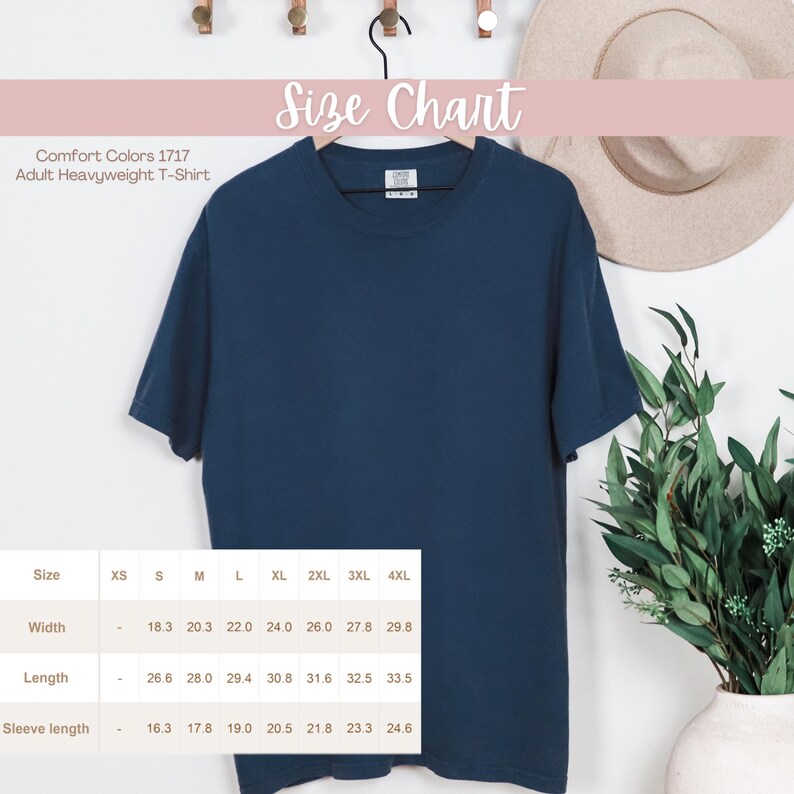 May include: A navy blue Comfort Colors 1717 adult heavyweight t-shirt hanging on a wooden hanger. The size chart shows measurements in inches for width, length, and sleeve length, ranging from XS to 4XL.