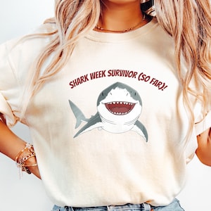 面白いシャークウィークサバイバーコンフォートカラーTシャツ - 皮肉な生理シャツ