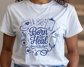 May include: White t-shirt with a blue graphic design featuring medical symbols and the text "Born to Heal forced to chart." The design includes a stethoscope, heart monitor, and other medical-related illustrations.