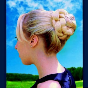 May include: A woman with blonde hair styled in a braided bun. She is wearing a black sleeveless dress and looking off to the side. The background is a blue sky with white clouds.