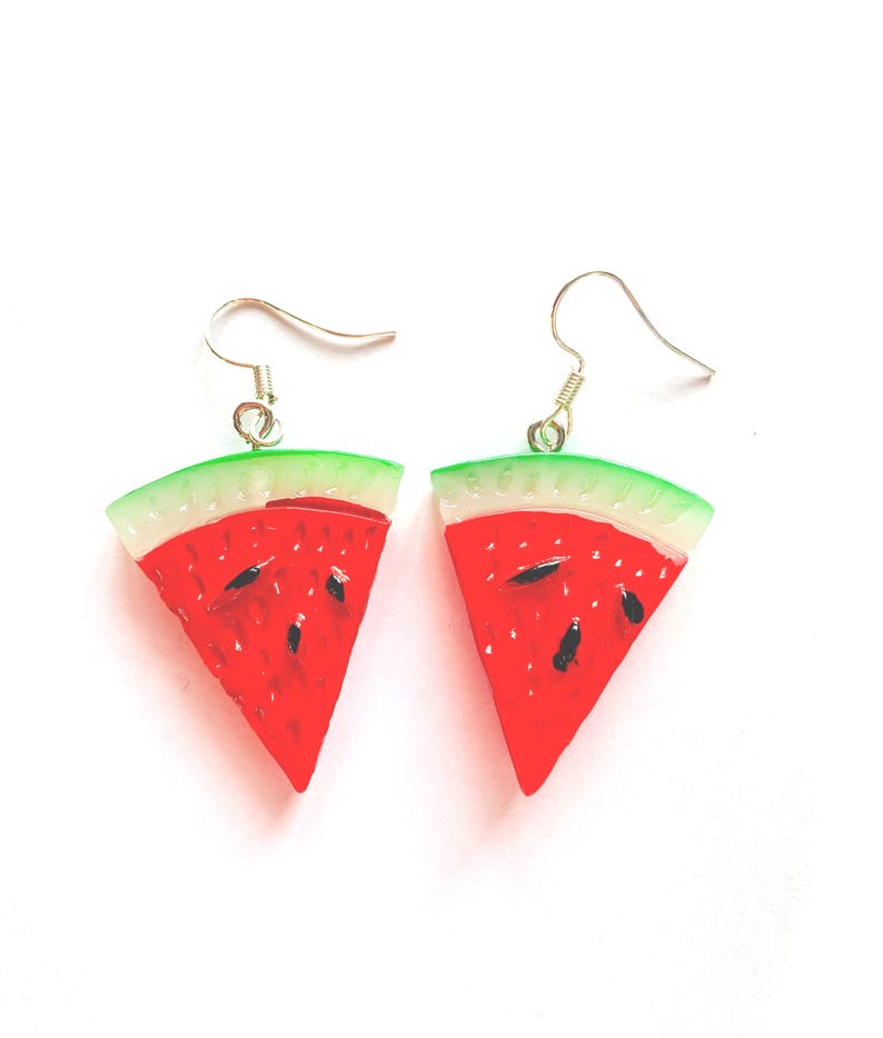 K&ouml;nnte beinhalten: Ein Paar Ohrringe in Form von Wassermelonenst&uuml;cken. Jeder Ohrring hat ein rotes, wei&szlig;es und gr&uuml;nes Design mit schwarzen Samendetails. Die Ohrringe haben silberfarbene Fischhaken-Ohrdr&auml;hte.