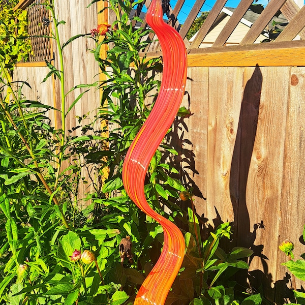 Hand blown glass spiral ribbon, red with orange highlights.