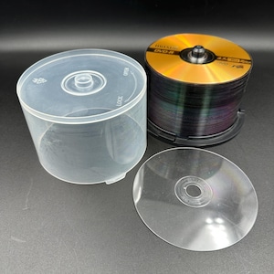 May include: A stack of gold and black DVD-R discs with a clear plastic case and a single disc. The discs are stacked in a black holder. The case is clear and has an open/lock mechanism.