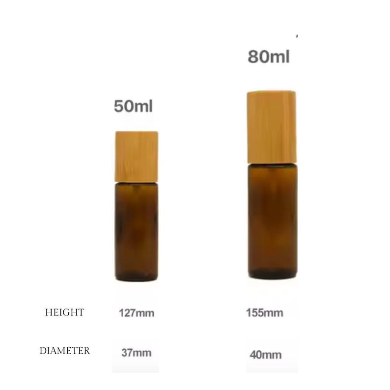 May include: Two amber glass roll-on bottles with wooden caps. The smaller bottle is 127mm tall and holds 50ml. The larger bottle is 155mm tall and holds 80ml. The diameter of the smaller bottle is 37mm, and the larger is 40mm.