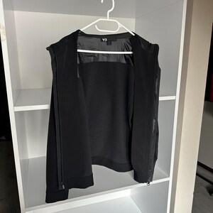 K&ouml;nnte beinhalten: Ein rustikales Holzschild mit dem handgeschriebenen Wort "Welcome". Das Schild ist wei&szlig; gestrichen und hat einen Used-Look. Ein kleines Herz ist unten angebracht. Der Hintergrund ist eine verschwommene Holzstruktur.