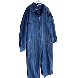 May include: A blue denim jumpsuit with a zipper closure and multiple pockets. The jumpsuit has a relaxed fit and is made of a durable fabric.