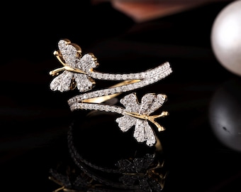 May include: A gold ring with two butterfly designs set with clear sparkling stones. The ring is designed to wrap around the finger.