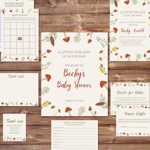May include: A collection of baby shower stationery with a whimsical mushroom and floral design. Includes invitations, bingo cards, thank you notes, and advice cards. The color palette features cream, red, and green elements, perfect for a baby shower.