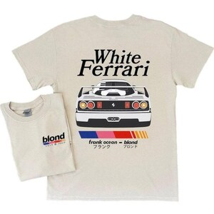 K&ouml;nnte beinhalten: Zwei beige T-Shirts. Eines zeigt "White Ferrari" &uuml;ber einer wei&szlig;en Autoillustration. Das andere hat "blond" mit japanischem Text. Beide haben einen Rundhalsausschnitt. Die Autoillustration hat einen schwarzen Streifen.
