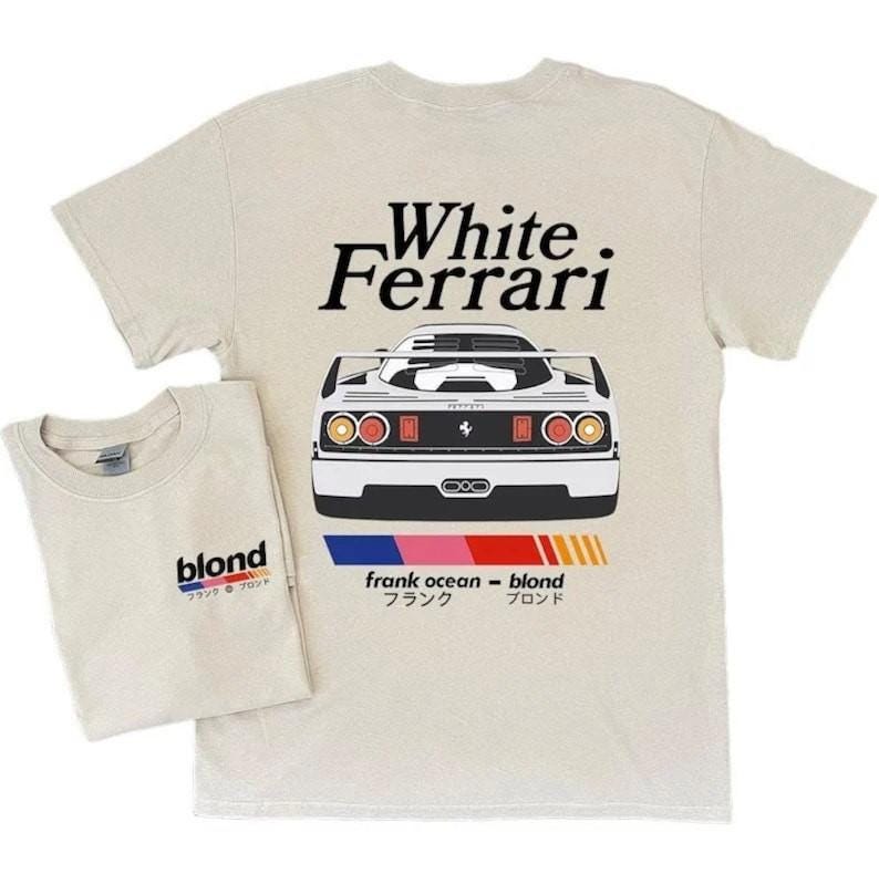 K&ouml;nnte beinhalten: Zwei beige T-Shirts. Eines zeigt "White Ferrari" &uuml;ber einer wei&szlig;en Autoillustration. Das andere hat "blond" mit japanischem Text. Beide haben einen Rundhalsausschnitt. Die Autoillustration hat einen schwarzen Streifen.