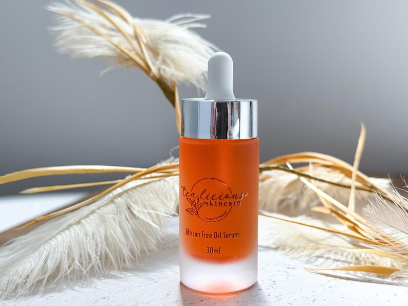 May include: A clear glass bottle with a silver cap and a dropper. The bottle contains a light orange liquid and has a label that reads "TeaLicious Skincare" and "African Free Oil Serum 30ml".