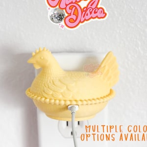 May include: A yellow chicken-shaped wall charger with a charging cable plugged in. Above the charger is a sticker with the text "Howdy Disco" in pink and orange. The text "MULTIPLE COLOR OPTIONS AVAILABLE" is also visible.