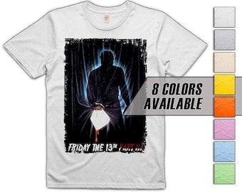 Könnte beinhalten: Weißes T-Shirt mit einer Grafik aus dem Horrorfilm "Freitag der 13. Teil III". Das Design zeigt eine Silhouette, die eine Waffe hält, mit dem Filmtitel in Rot. Der Text "8 Farben verfügbar" wird ebenfalls angezeigt.