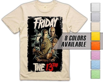 Puede incluir: Una camiseta color crema con un gráfico de la película "Viernes 13". El diseño incluye el texto "FRIDAY" y "THE 13TH" con un borde negro. La imagen muestra un personaje enmascarado sosteniendo un hacha. Hay ocho opciones de color disponibles.