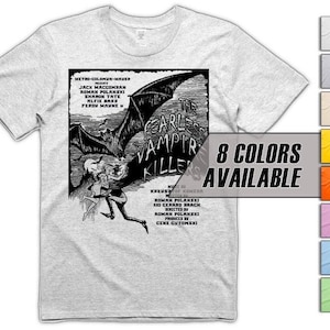 May include: Pale grey t-shirt with a black and white graphic from "The Fearless Vampire Killers". The graphic shows a bat, figures, and text. The shirt also has a text box that says "8 Colors Available".