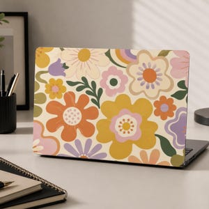 May include: A laptop skin featuring a repeating pattern of stylized flowers in shades of mustard yellow, burnt orange, soft pink, lavender, and olive green on a cream background. The design includes various floral shapes and green leaves.