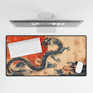 May include: A mouse mat featuring a colourful illustration of a dragon with a red and orange background. The dragon is blue and black with a white and yellow mane. The mouse mat is rectangular and has a black border.