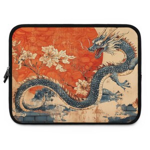 May include: A laptop sleeve featuring a vintage-style illustration of a blue dragon with a red sun and white flowers in the background.