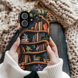 May include: A phone case with a detailed illustration of a bookshelf with books, fairies, and foliage. The case has a dark background with a wooden bookshelf design, and the books are in various colours. The case has a camera cutout.