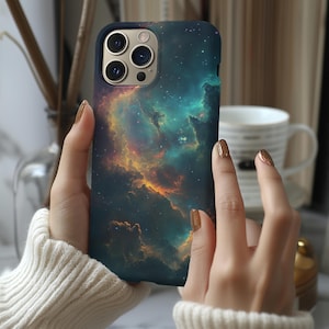 May include: A phone case with a galaxy-themed design. The case features a dark blue background with swirling clouds of orange, yellow, and green. The phone case has a cutout for the camera lens.