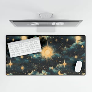 May include: A dark blue desk mat with a celestial design featuring stars, moons, and a sun. The mat has a white keyboard and a white mouse on it.