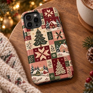 May include: A smartphone case featuring a patchwork design of holiday-themed illustrations including snow-covered houses, evergreen trees, and geometric star patterns in shades of red, green, cream, and pink with a triple camera lens cutout.