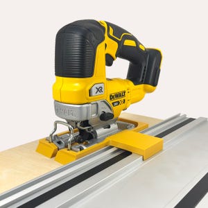 Puede incluir: Una sierra de calar DeWalt XR 20V amarilla y negra con una hoja negra y plateada está unida a un riel guía amarillo y plateado. La sierra de calar está sobre una superficie de madera clara.