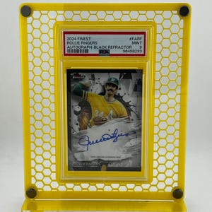 Puede incluir: Un expositor amarillo que contiene una tarjeta de b&eacute;isbol. La tarjeta presenta una imagen de Rollie Fingers, un aut&oacute;grafo y el texto "2024 Finest". El expositor tiene un patr&oacute;n de panal y est&aacute; hecho de un material transparente.