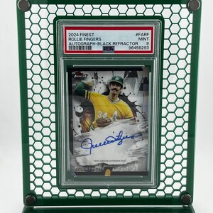Puede incluir: Un marco de exhibici&oacute;n verde sostiene una tarjeta de b&eacute;isbol con Rollie Fingers. La tarjeta est&aacute; etiquetada como "2024 Finest Autograph-Black Refractor" e incluye el texto "TOPPS CERTIFIED AUTOGRAPH ISSUE". El marco tiene un patr&oacute;n de panal.