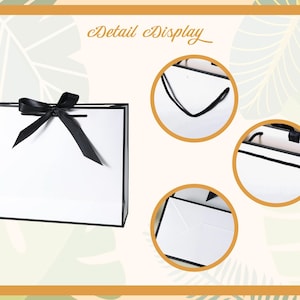 May include: White gift bag with a black border and a black satin ribbon bow. The bag has black handles and a black lining. The bag is shown in detail with close-up images of the handles, lining, and bow.